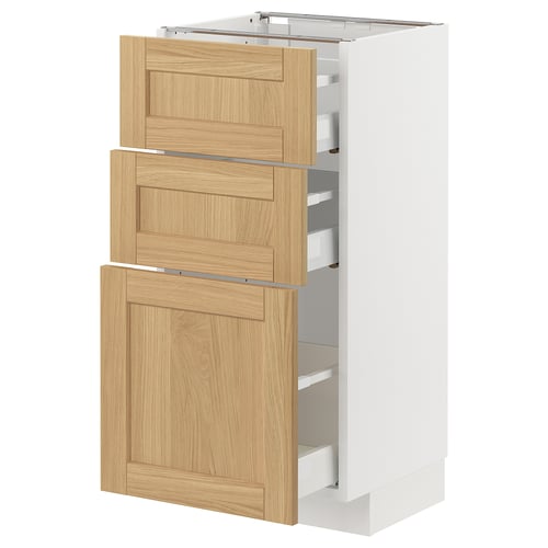 A white METOD kitchen cabinet with oak-veneer drawers featuring bevelled edges.