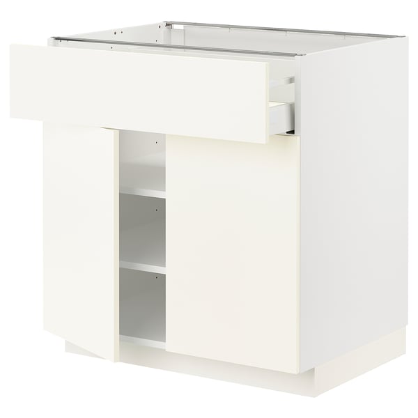 A white METOD kitchen cabinet with a smooth drawer. It a sleek, modern design with a single adjustable shelf inside.