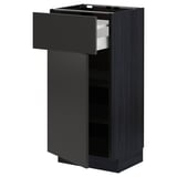 Modern black kitchen cabinet with open drawer.
