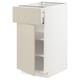 White METOD kitchen cabinet with beige drawer and open section.