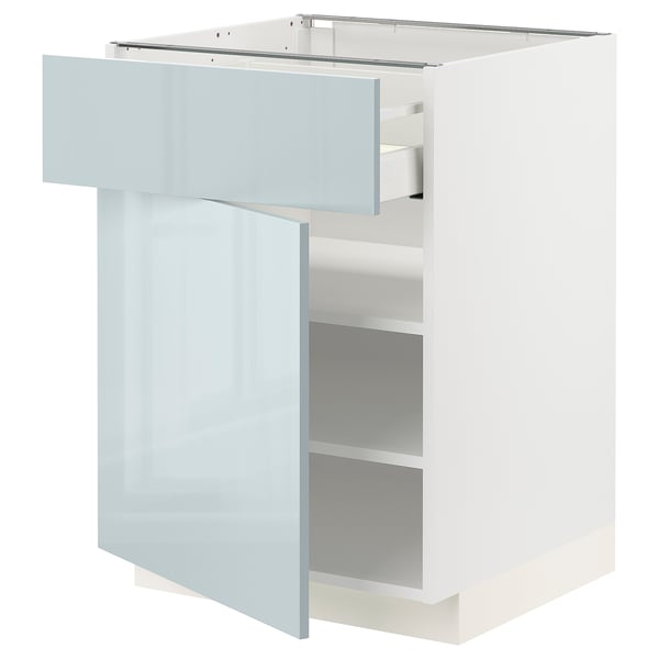 Displays a white METOD kitchen cabinet with a light blue-gray glossy drawer and door, featuring an open drawer showcasing inner shelves.