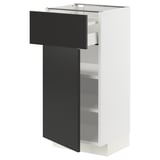 A white METOD kitchen cabinet with a black drawer and door. The cabinet adjustable shelves and a modern design.