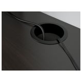 Dark desk with circular cable outlet, showcasing a neat cable management feature.