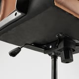 Close-up of MILLBERGET chairs adjustable base and armrest. Shows quality materials and design.