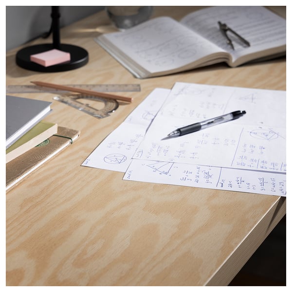 Wooden desk with open notebooks, pencils, ruler, and equations. Study or design workspace.
