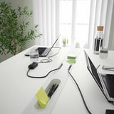 Modern conference table with laptops, accessories, and cable management.