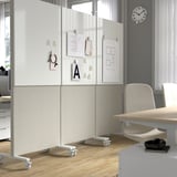 Office partition with wheels, whiteboard, and notes pinned on it. Suitable for meetings and workshops, providing sound absorbency and space division.