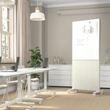 Modern office space with MITTZON partition screen. Whiteboard with sketches, plant, laptop, and chair nearby.