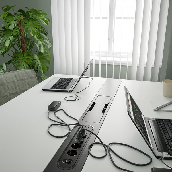 Desk with 3 laptops, plant, light.