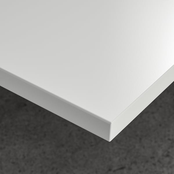 Modern white office table with sleek, wipe-clean surface on dark floor.