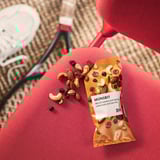 Snack bag labeled MUNSBIT, showing mix of nuts and berries, partially opened with contents spilled out.