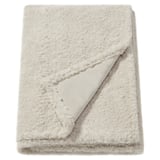 Fluffy off-white blanket, textured, folded rectangle, made from soft, recycled polyester.