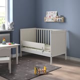 Childs bedroom with NATTAPA bed, bookshelf, toys, and spotted rug.