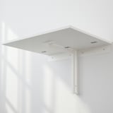White wall-mounted table top folded up, fixed with brackets, showing its space-saving feature.