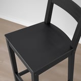 Black wooden stool with curved backrest, solid construction, comfortable seat.
