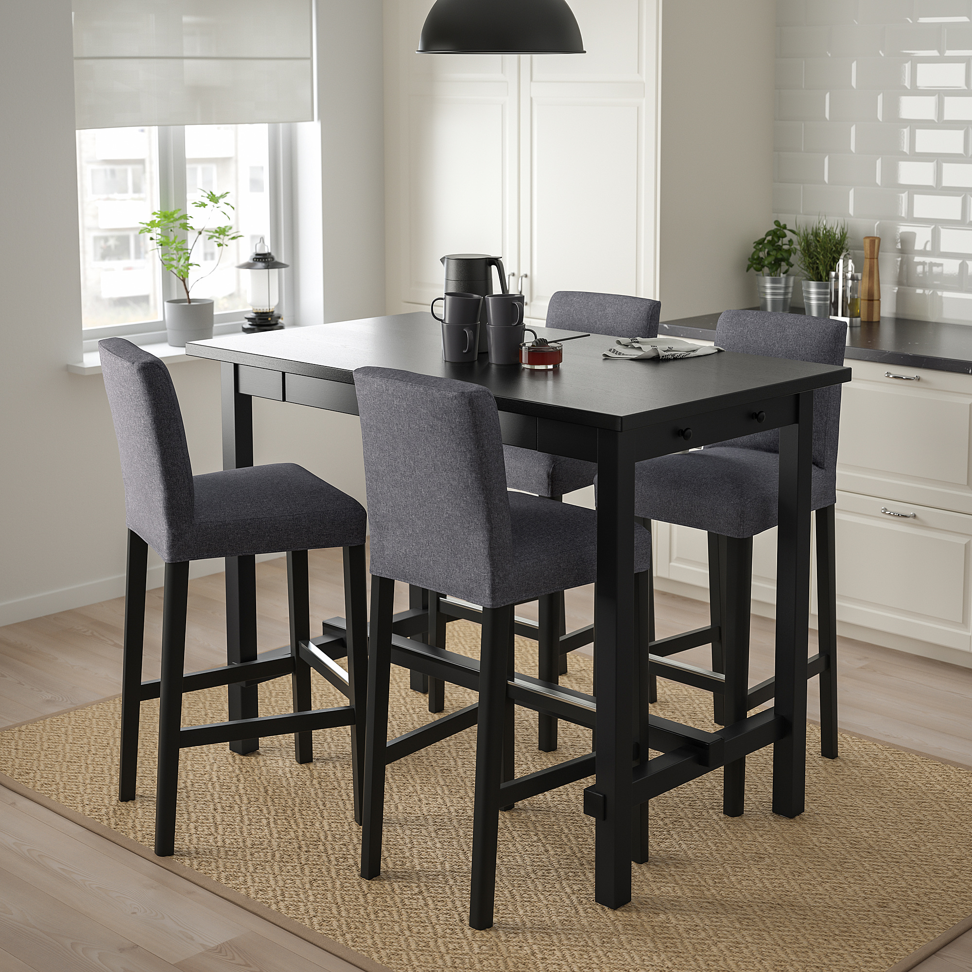 Small, modern black bar set with grey cushioned stools in a bright kitchen.