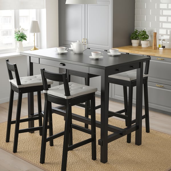 Black NORDVIKEN bar set with drawer, cushioned chairs, near window in kitchen.