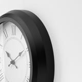 Modern silent black clock with white face and roman numerals, showingii:05.