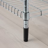 Metal rack leg with adjustable black foot for stability on uneven surfaces.