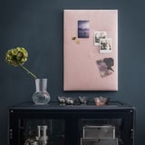 Modern dark room with black sideboard, vase, photos, candles, and stored items.
