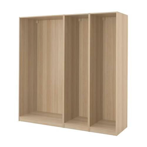 An ikea PAX wardrobe frame in oak veneer. Its rectangular, light-colored, and divided into three sections.