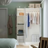 PAX wardrobe with mirrored doors, open showcasing clothes and storage.