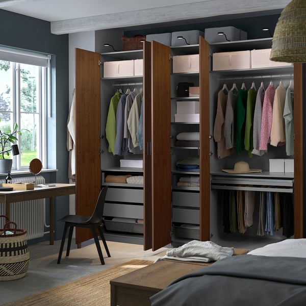Organised wardrobe with folded clothes, hanging garments, and storage bins in a bedroom setting.