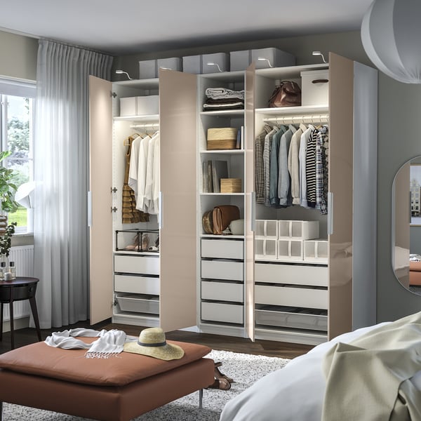 Bedroom with open wardrobe, clothes, and storage.