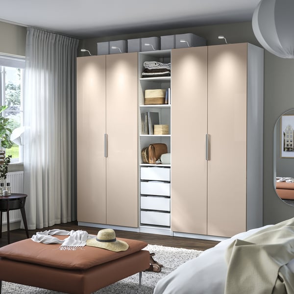 Modern bedroom with large beige wardrobe, mirror, and bench.