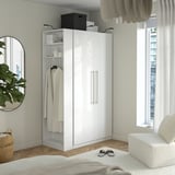 White PAX wardrobe with clothes, mirror, window, and rug.