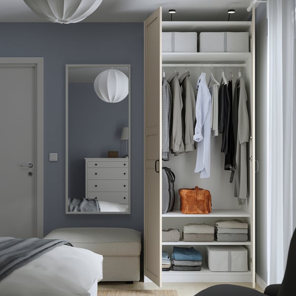 Modern blue bedroom with open wardrobe and mirror.