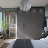 Modern bedroom with sleek gray PAX wardrobes, a white pendant light, and a cozy bed.