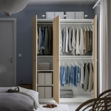 Open wardrobe with clothes and storage boxes, showing internal organization with hanging rails and shelves.