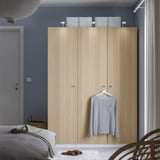 Modern bedroom with large PAX wardrobe, striped shirt, calm grey-blue wall, and woven basket.