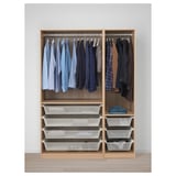 A wooden wardrobe named PAX with hanging shirts, jackets, and pull-out mesh drawers.