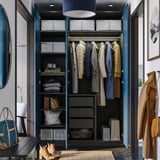 Open wardrobe displaying clothes, folded items, and drawers with organizational baskets.