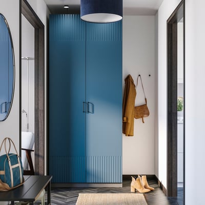 Modern entryway with blue cabinet, mirror, rug, and coat/bag.