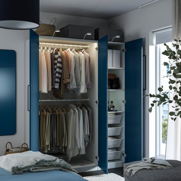 Bedroom closet with clothes, including hanging rack, shelves, and drawers, featuring adjustable feet and integrated lighting.
