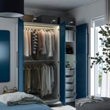Bedroom closet with clothes, including hanging rack, shelves, and drawers, featuring adjustable feet and integrated lighting.