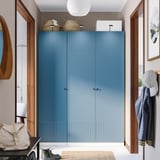 Modern hall with large blue PAX wardrobe, wood accents, hanging jackets, and storage basket.