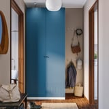 Modern PAX wardrobe with blue cabinet, mirrors, and hooks for accessories.
