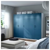 Blue ribbed PAX wardrobe in bedroom with ottoman and bed.