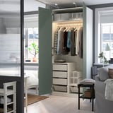 A modern, green PAX wardrobe with clothing, shelves, drawers, and lighting, providing organized storage and style.