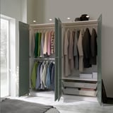 Open wardrobe showing clothes, accessories, and drawers. Interior lighting illuminates contents.