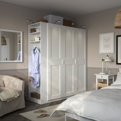 Large white PAX wardrobe with multiple compartments, doors, and shelves, dominating the room with ample storage.