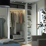 Well-lit closet with clothes hangers, shelves, and storage boxes. Integrated lighting and adjustable feet for uneven floors.