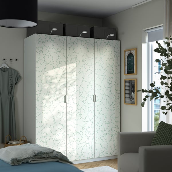 White PAX wardrobe with green leaves, central and large with multiple compartments.