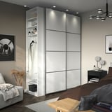 Modern bedroom with white PAX wardrobe, sliding doors, and stylish decor.