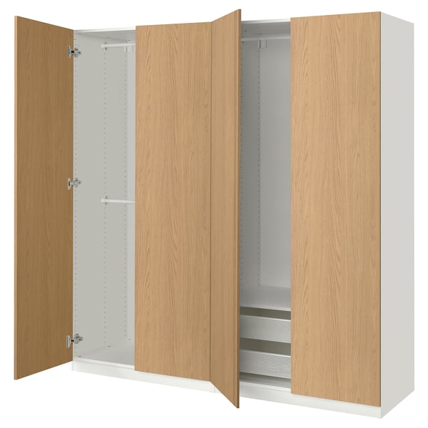 An ikea PAX wardrobe in white and natural oak with both doors open, revealing adjustable shelves and mesh drawers.