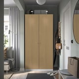 Modern entryway with tall PAX wardrobe, hooks, curtains, and round mirror.